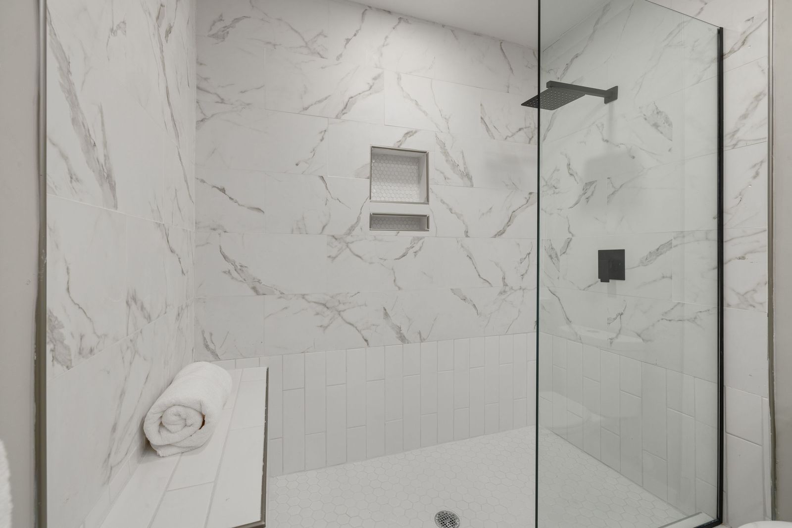 Walk-in shower with a built-in seat and no tub wall to step over