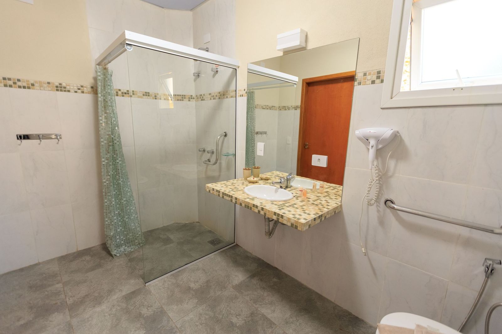 Accessible bathroom with a horizontal grab bar near the toilet and sink